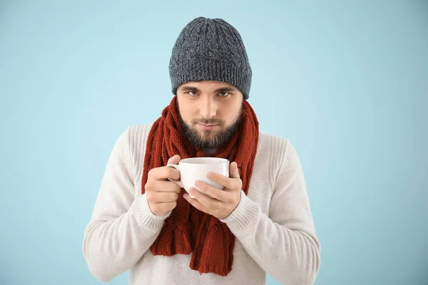 Portrait of sick man with hot tea on color background — Stock Photo, Image