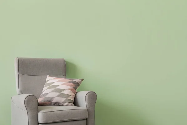 Sillón suave con almohada cerca de la pared de color — Foto de Stock