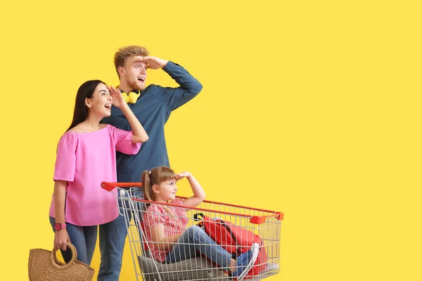 Familia con carrito de compras sobre fondo de color —  Fotos de Stock