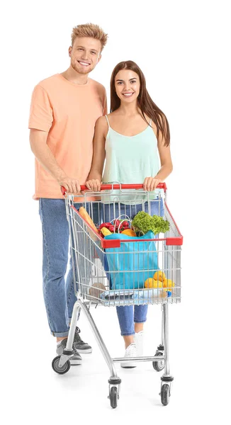 Young couple with shopping cart on white background — Stock Photo, Image