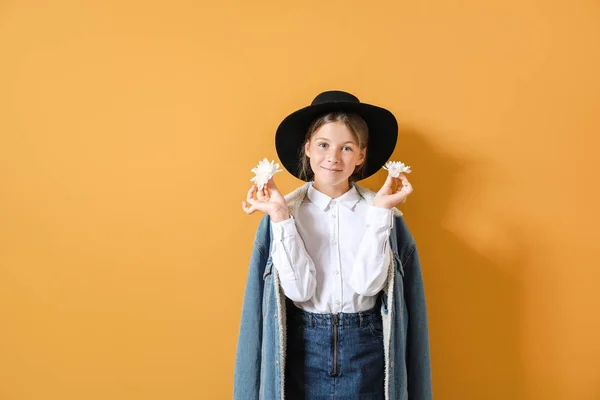 Niña con estilo con flores en el fondo de color — Foto de Stock