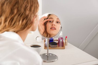 Güzel genç bir bayanın yatak odasına makyaj yaptığı sabah.