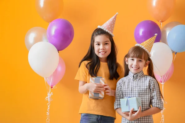 Little girls with Birthday gifts on color background — Stock Photo, Image