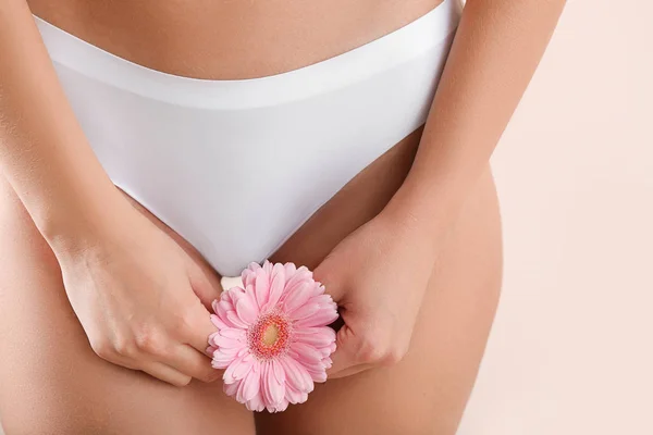 Junge Frau mit Blume auf hellem Hintergrund, Nahaufnahme. Frauenheilkunde-Konzept — Stockfoto