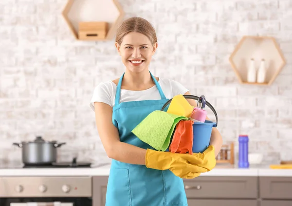 Female janitor with cleaning supplies in kitchen — Stock Photo, Image