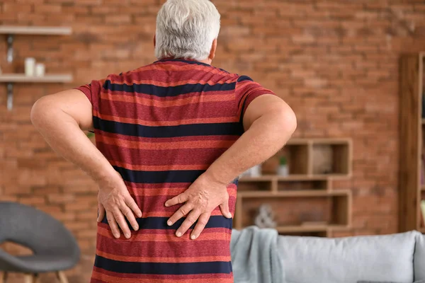 Senior man suffering from back pain at home — Stock Photo, Image