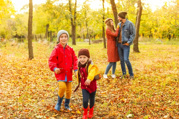 Familia feliz descansando en el parque de otoño —  Fotos de Stock