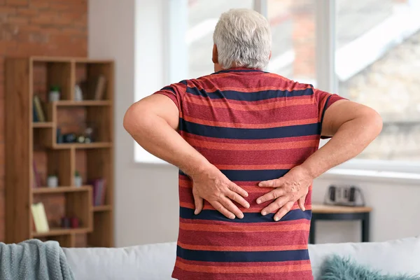 Senior man suffering from back pain at home — Stock Photo, Image