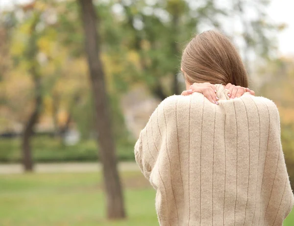 Young woman suffering from back pain outdoors — Stock Photo, Image