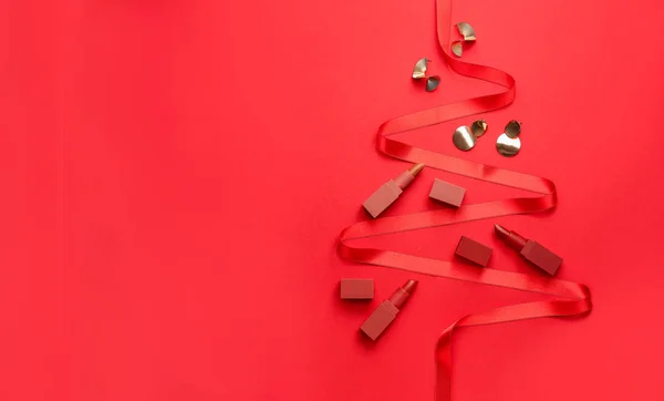 Hermoso árbol de Navidad hecho de lápices labiales, joyas y cinta en el fondo de color — Foto de Stock