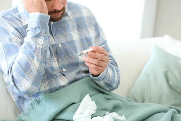 Man ill with flu measuring temperature at home — Stock Photo, Image