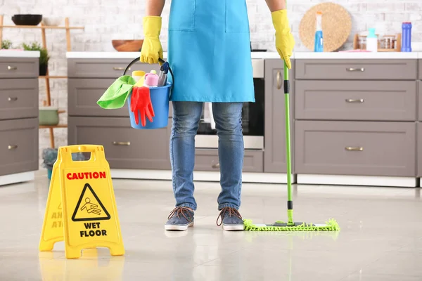 Conserje masculino con artículos de limpieza en la cocina — Foto de Stock