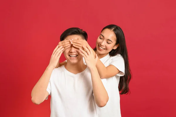 Portrait of happy young Asian couple on color background — Stock Photo, Image