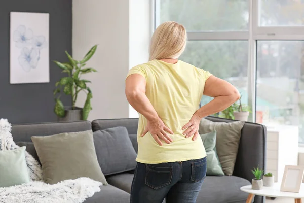 Rijpe vrouw die lijden aan rugpijn thuis — Stockfoto