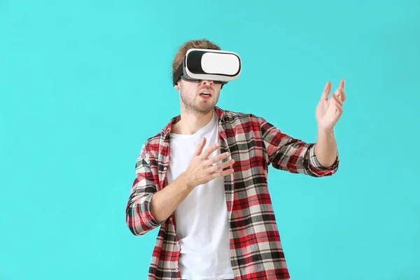 Junger Mann mit VR-Brille auf farbigem Hintergrund — Stockfoto