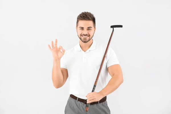 Snygg manlig golfare visar Ok på ljus bakgrund — Stockfoto