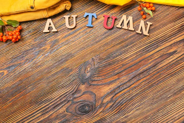 Woord Herfst met kleding op houten achtergrond — Stockfoto
