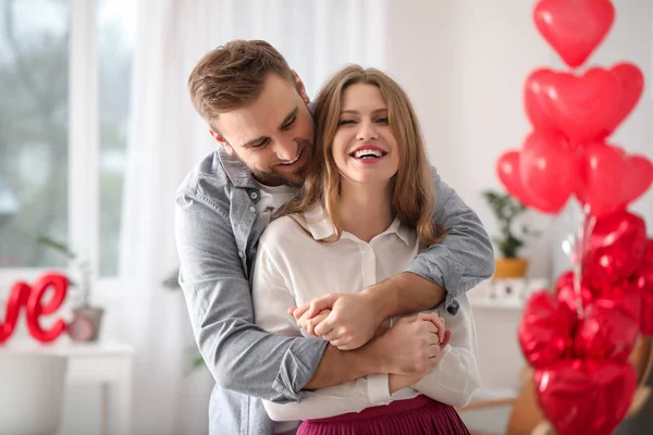 Feliz pareja joven celebrando el Día de San Valentín en casa —  Fotos de Stock