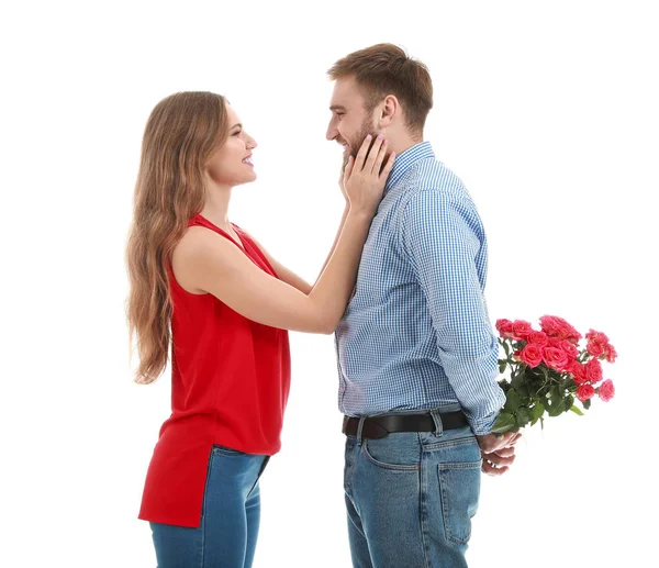 Mann versteckt Blumenstrauß für seine Freundin vor weißem Hintergrund. Valentinstag-Feier — Stockfoto