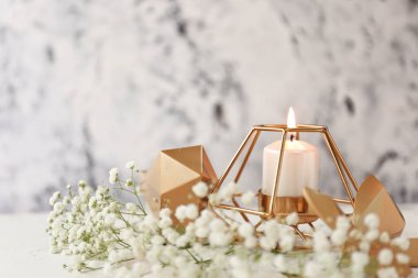 Beyaz arka planda çiçekli parlayan mum