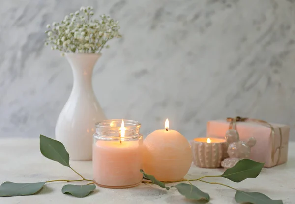 Glowing candles with eucalyptus on table — Stock Photo, Image