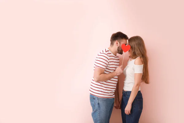 Felice giovane coppia con cuore rosso su sfondo di colore. Festa di San Valentino — Foto Stock