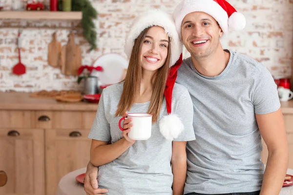 Jovem casal feliz na cozinha na véspera de Natal — Fotografia de Stock