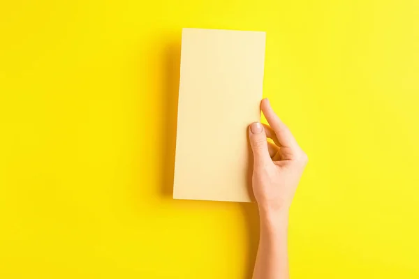 Mano femenina con menú en blanco sobre fondo de color —  Fotos de Stock