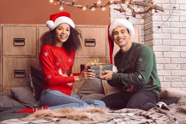 Feliz casal afro-americano com presente de Natal em casa — Fotografia de Stock