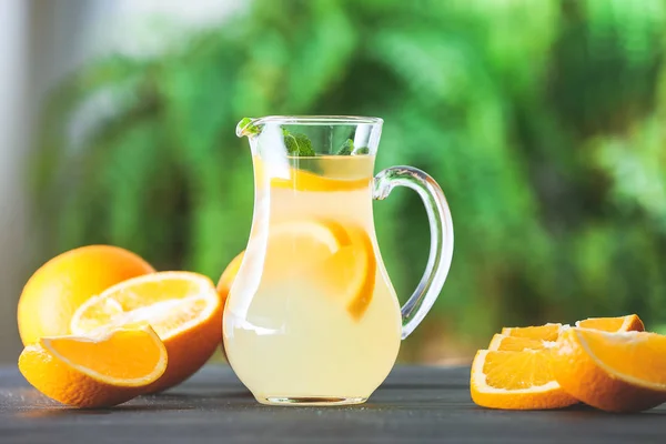 Jug of fresh lemonade on table outdoors — Stock Photo, Image