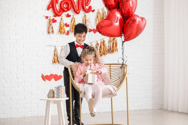 Niedlicher Junge begrüßt kleines Mädchen mit Valentinstag drinnen — Stockfoto