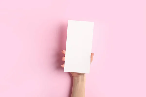 Female hand with blank menu on color background — Stock Photo, Image