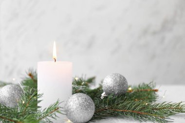 Beyaz arka planda Noel dekoru olan parlak bir mum.