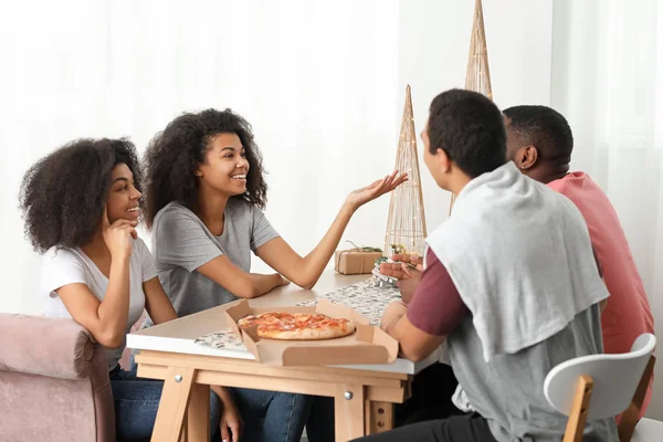Junge afrikanisch-amerikanische Freunde essen leckere Pizza zu Hause — Stockfoto