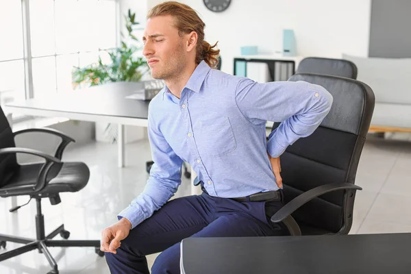 事務所で腰痛に苦しむ若い男 — ストック写真