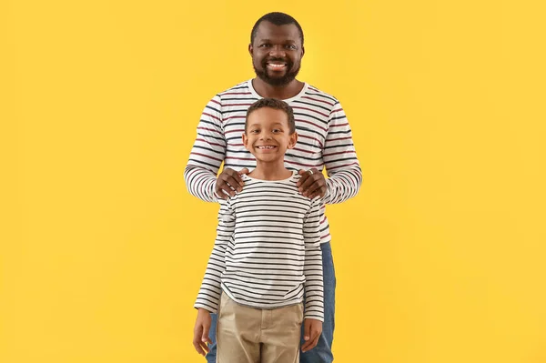 Retrato de homem afro-americano com seu filhinho sobre fundo de cor — Fotografia de Stock