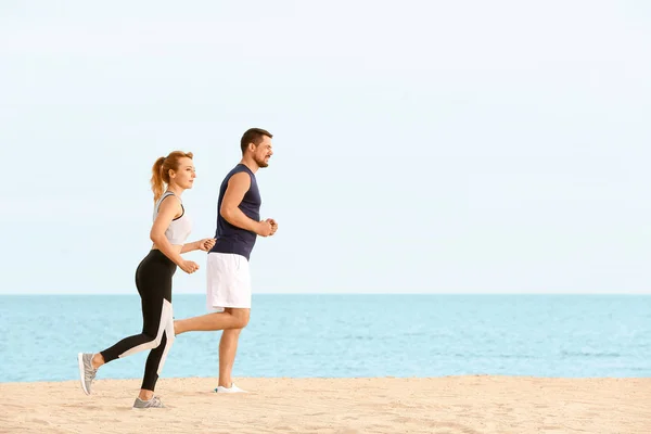Sporty couple running at sea resort — Stock Photo, Image