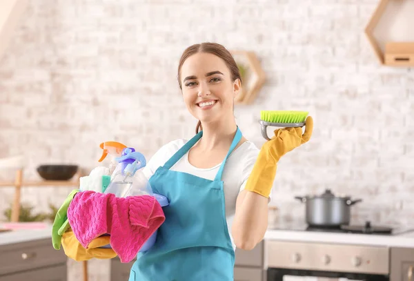 Female janitor with cleaning supplies in kitchen — Stock Photo, Image