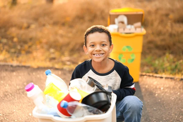 屋外でゴミを集めるアフリカ系アメリカ人の少年。リサイクルの概念 — ストック写真