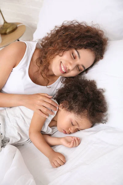 Niña afroamericana con madre durmiendo en la cama — Foto de Stock