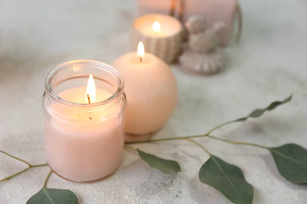 Glowing candles with eucalyptus on table — Stock Photo, Image