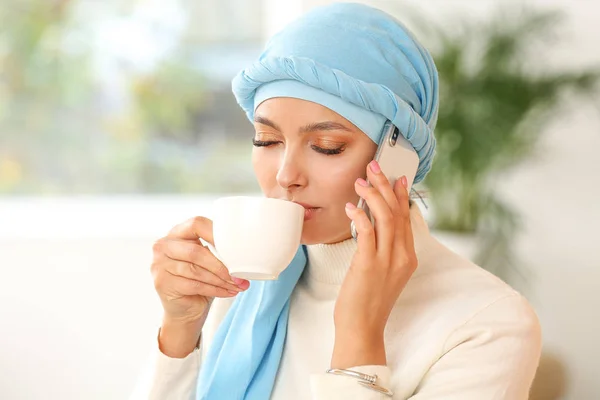 在家里喝茶时打电话聊天的漂亮穆斯林妇女的画像 — 图库照片