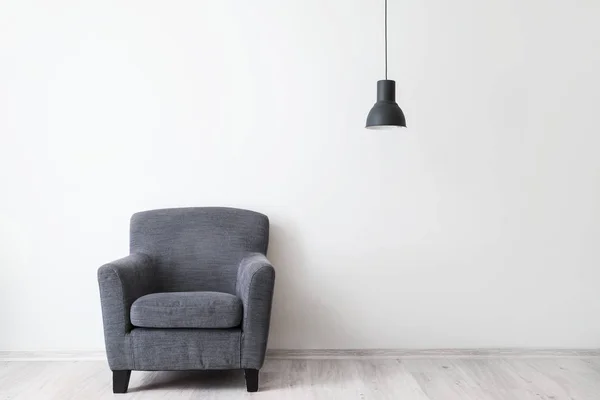 Elegante sillón cerca de la pared de luz — Foto de Stock