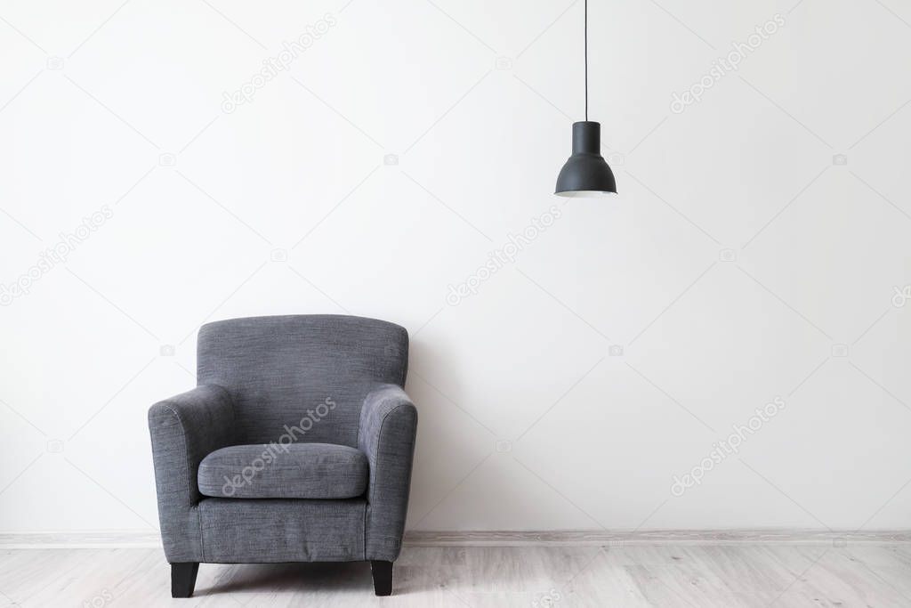 Stylish armchair near light wall