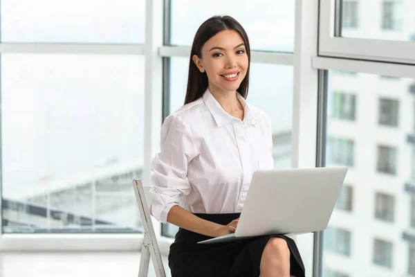 Mooie Aziatische zakenvrouw met laptop in kantoor — Stockfoto