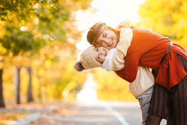 Portrait of happy mother and little daughter in autumn park — Stock Photo, Image