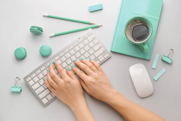 Female hands with PC keyboard and stationery on light background