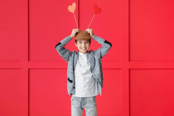 Roztomilý chlapeček s papírovými srdíčky na barevném pozadí. Valentýnská oslava — Stock fotografie