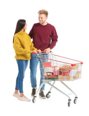 Beyaz arka planda Noel hediyeleriyle dolu alışveriş arabası olan genç bir çift.