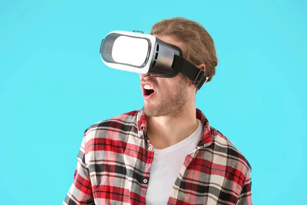 Young man with VR glasses on color background — Stock Photo, Image